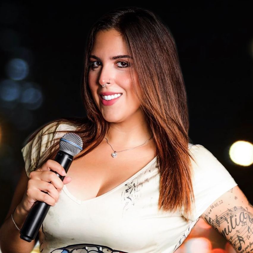 Female singer holding a microphone with bokeh lights in the background near The Morgan Resort Spa Village