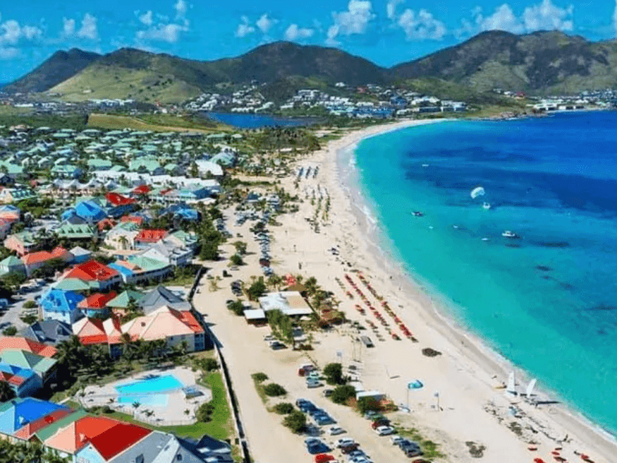Aerial view of Orient Beach with a long sandy beach and mountains near The Morgan Resort Spa Village