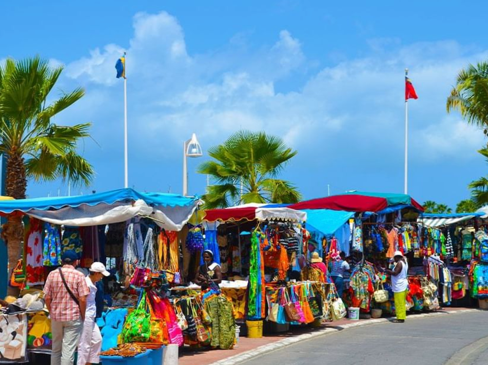 Tourist shops in Marigot with bright clothing and souvenirs under blue awnings near The Morgan Resort Spa Village
